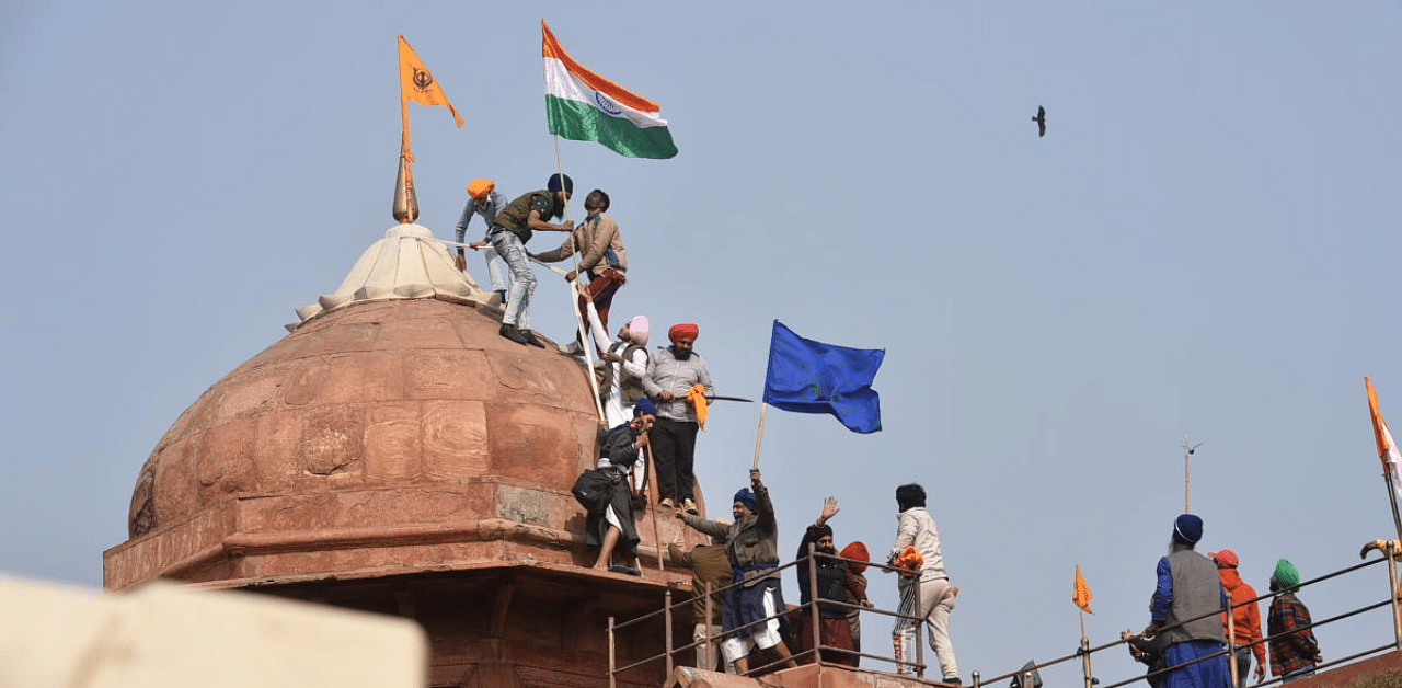 Farmers post flags on a dome of Red Fort after their tractor parade on Republic Day, in New Delhi. Credit: PTI Photo