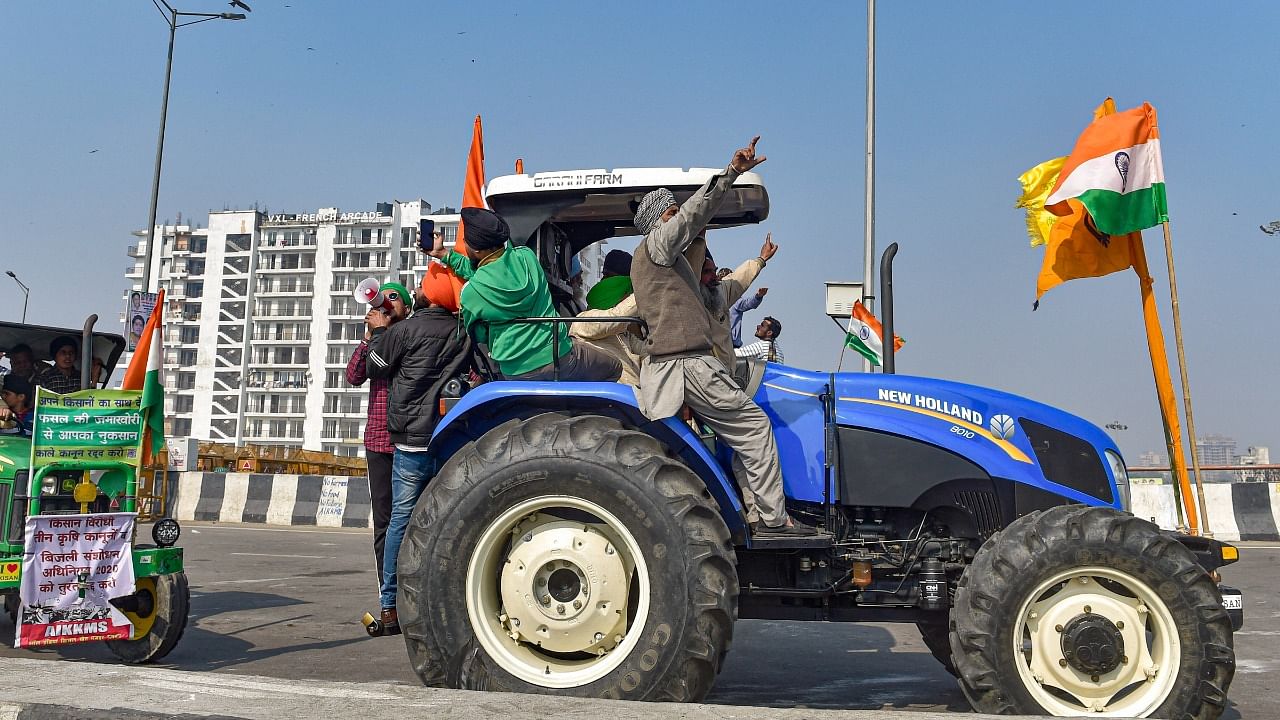 Farmers ride on tractors during their ongoing protest against the Center's new farm laws at the Ghazipur border in New Delhi. Credit: PTI Photo