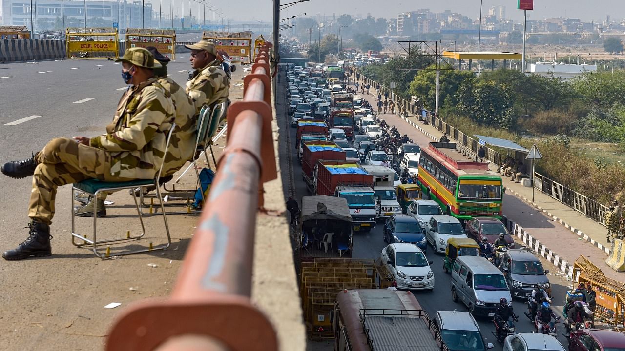 Security personnel block a flyover as traffic moves slowly on a road at farmers' protest site at the Ghazipur border in New Delhi. Credit: PTI Photo