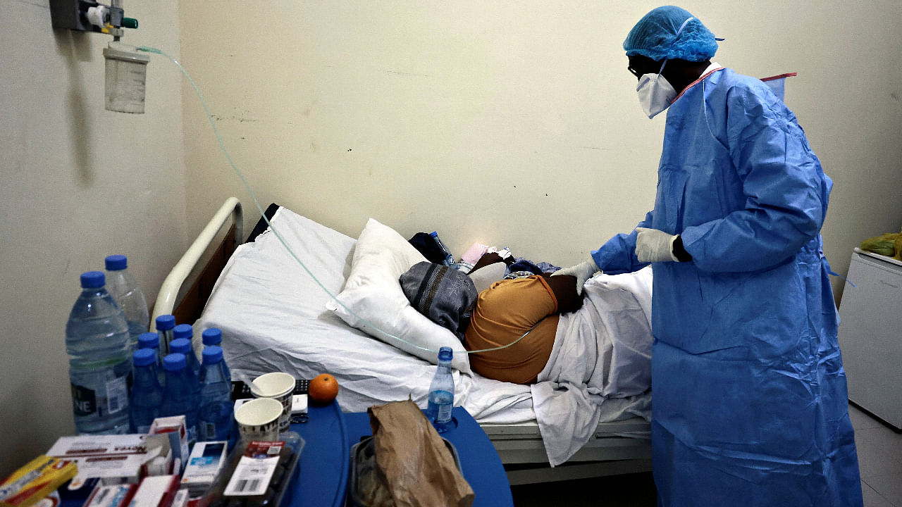 Professor Moussa Seydi, wearing his personal protective equipment (PPE) talks to a patient, who is suffering from the coronavirus disease in Dakar, Senegal. Credit: Reuters Photo