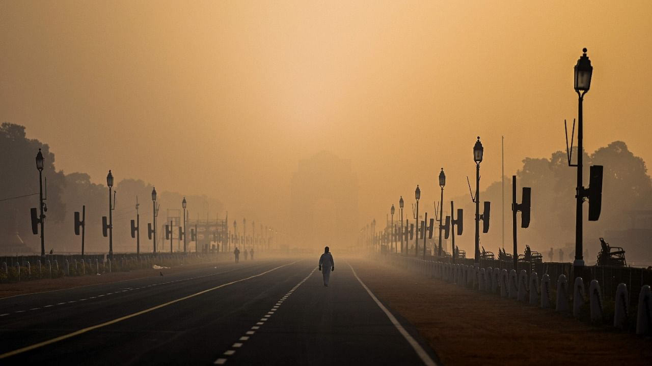 A man walks along Rajpath amid smoggy conditions in New Delhi. Credit: AFP Photo