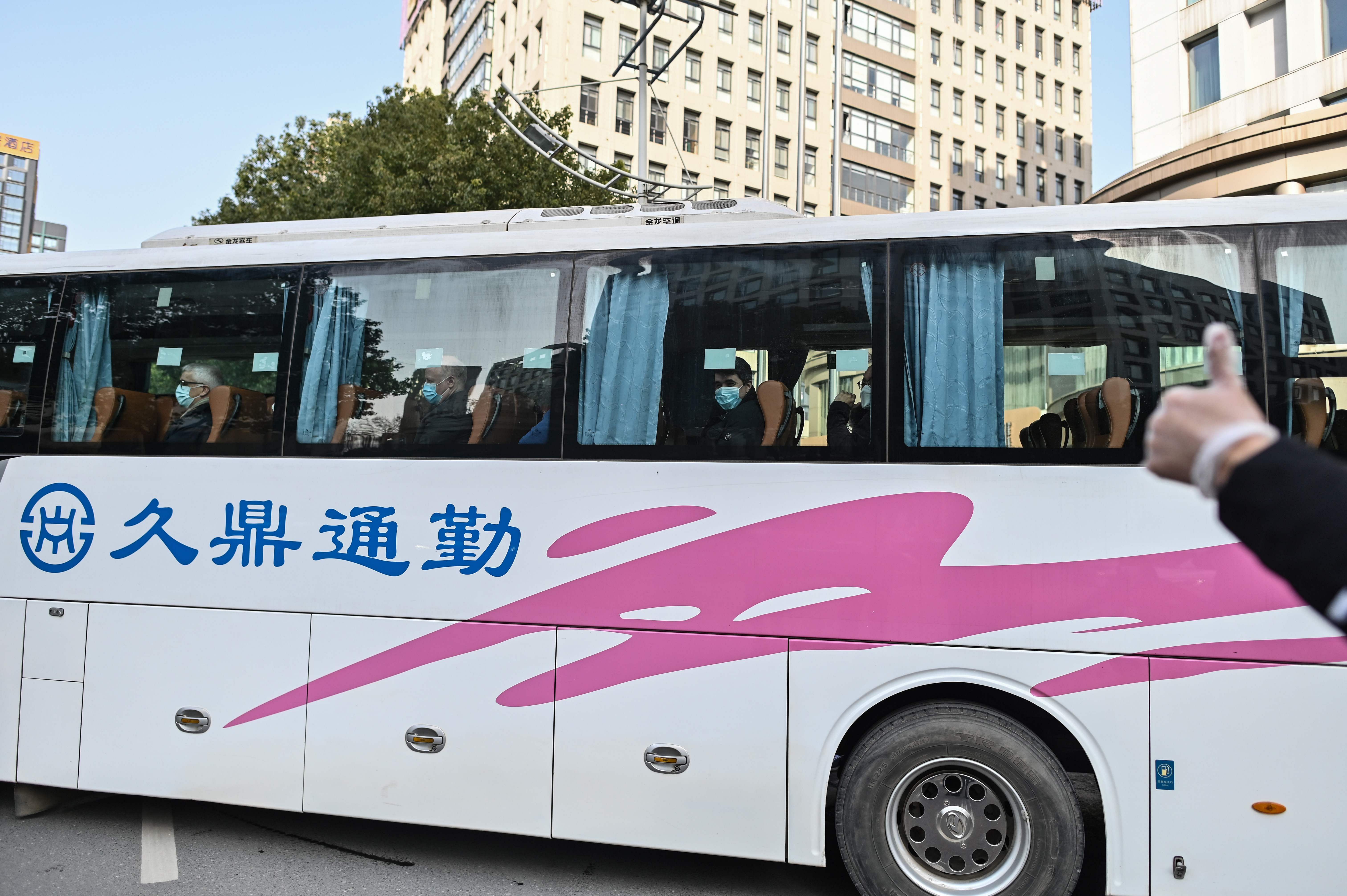 Members of the World Health Organization (WHO) team investigating the origins of the Covid-19 coronavirus pandemic leave The Jade Hotel on a bus after completing their quarantine in Wuhan. Credit: AFP Photo