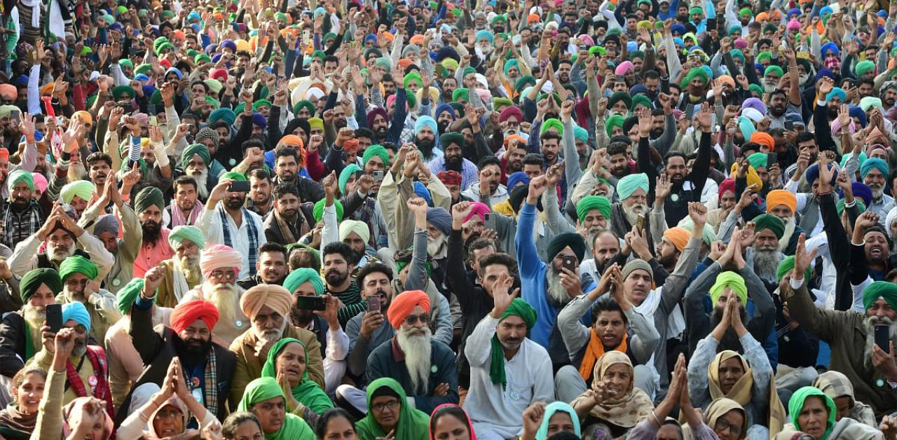 Farmers listen to a leader's speech during the ongoing protest at Tikri border. Credit: PTI photo. 