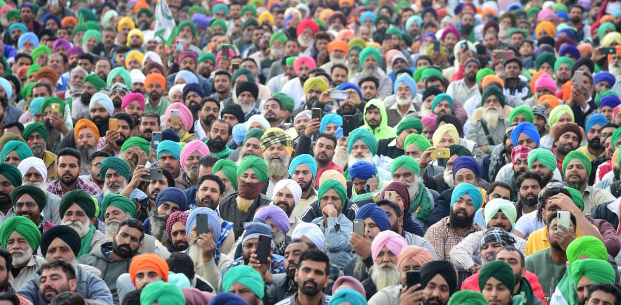 Farmers listen to a leader's speech during the ongoing protest at Tikri border. Credit: PTI photo. 