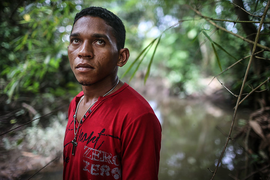 Former slave Elenilson de Conceição poses at a fazenda by a small pond which reminded him of the pond he was forced to use for drinking and bathing during his enslavement on April 12, 2015 in Santa Fé do Araguaia, Tocantins state, Brazil. Many slavery cases in Brazil occur on fazendas, including Elenilson's. Credit: Mario Tama/Getty Images
