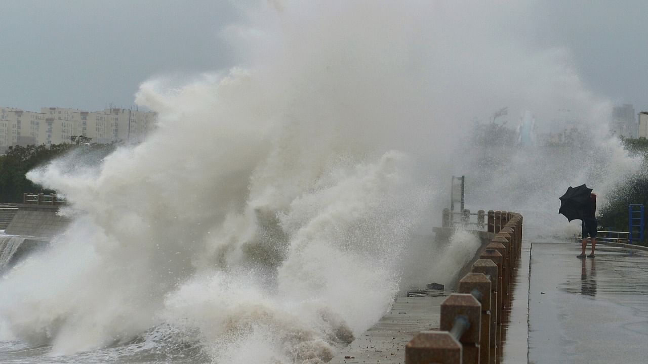 A wave brought by typhoon Lekima breaks on the shore next to a pedestrian in Qingdao, Shandong province, China August 11, 2019. Credit: Reuters Photo