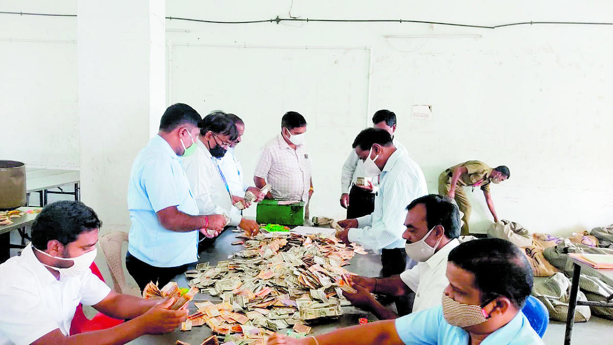 Temple staff count cash donation of Male Mahadeshwara Swami temple in Hanur taluk, Chamarajanagar district recently. DH Photo