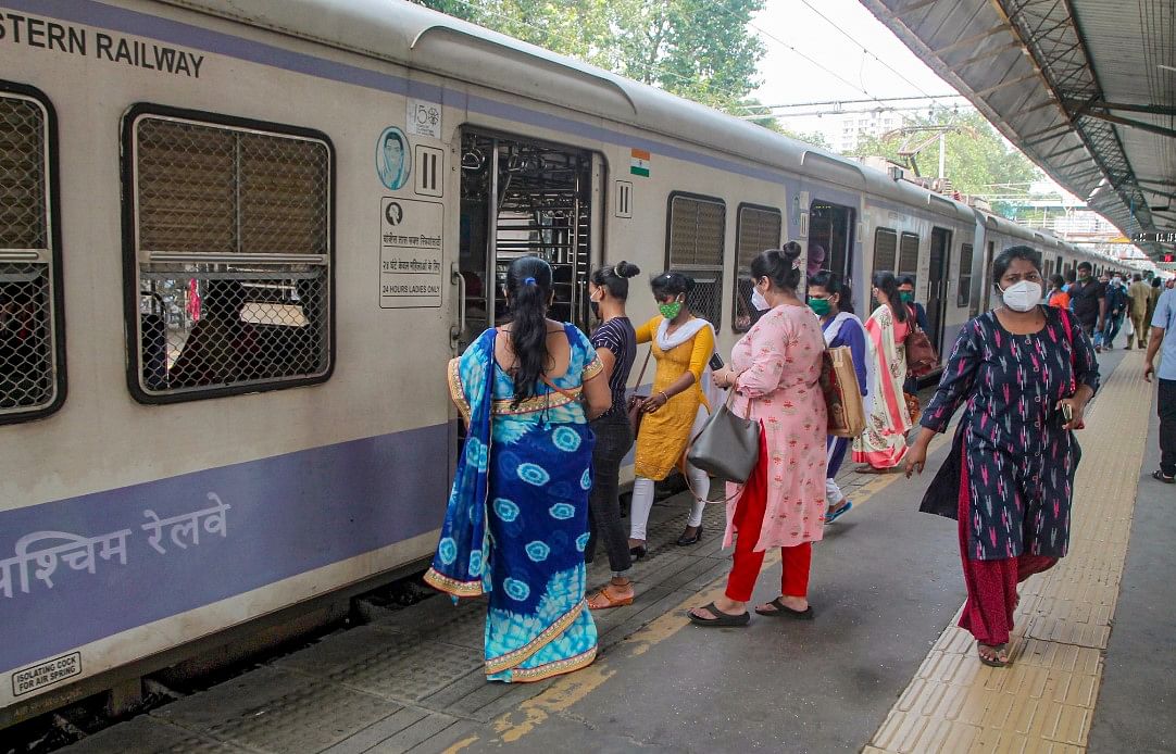 Women passengers board a local train after the authorities allowed them to commute during non-peak hours from 11 AM to 3 PM and from 7 PM till the end of the service, at CSMT in Mumbai, Wednesday, Oct. 21, 2020.
