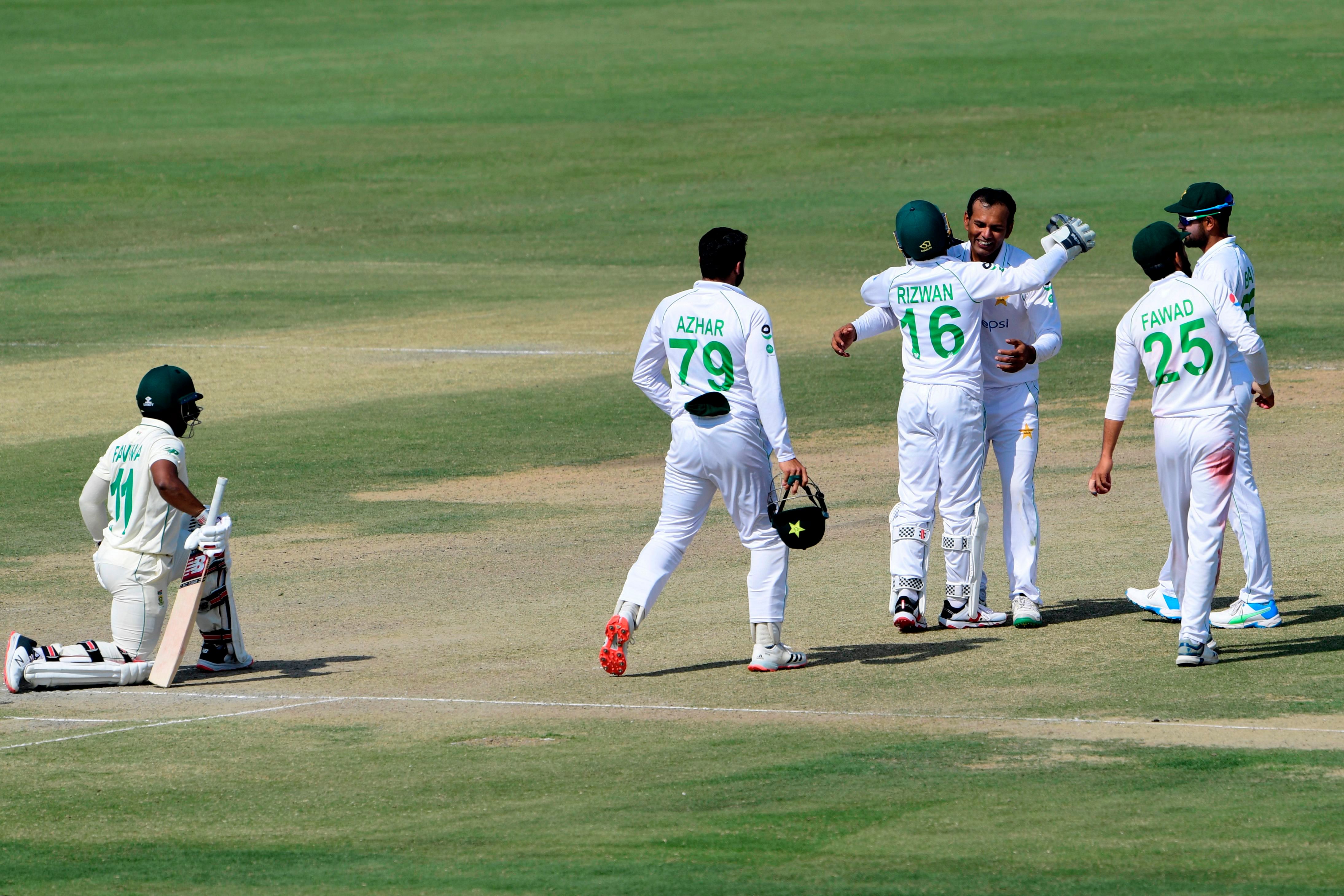 Pakistan's Nauman Ali (3R) celebrates with teammates after taking the wicket of South Africa's Temba Bavuma (L) during the fourth day of the first cricket Test match between Pakistan and South Africa at the National Stadium in Karachi on January 29, 2021. (Photo by Asif HASSAN / AFP)