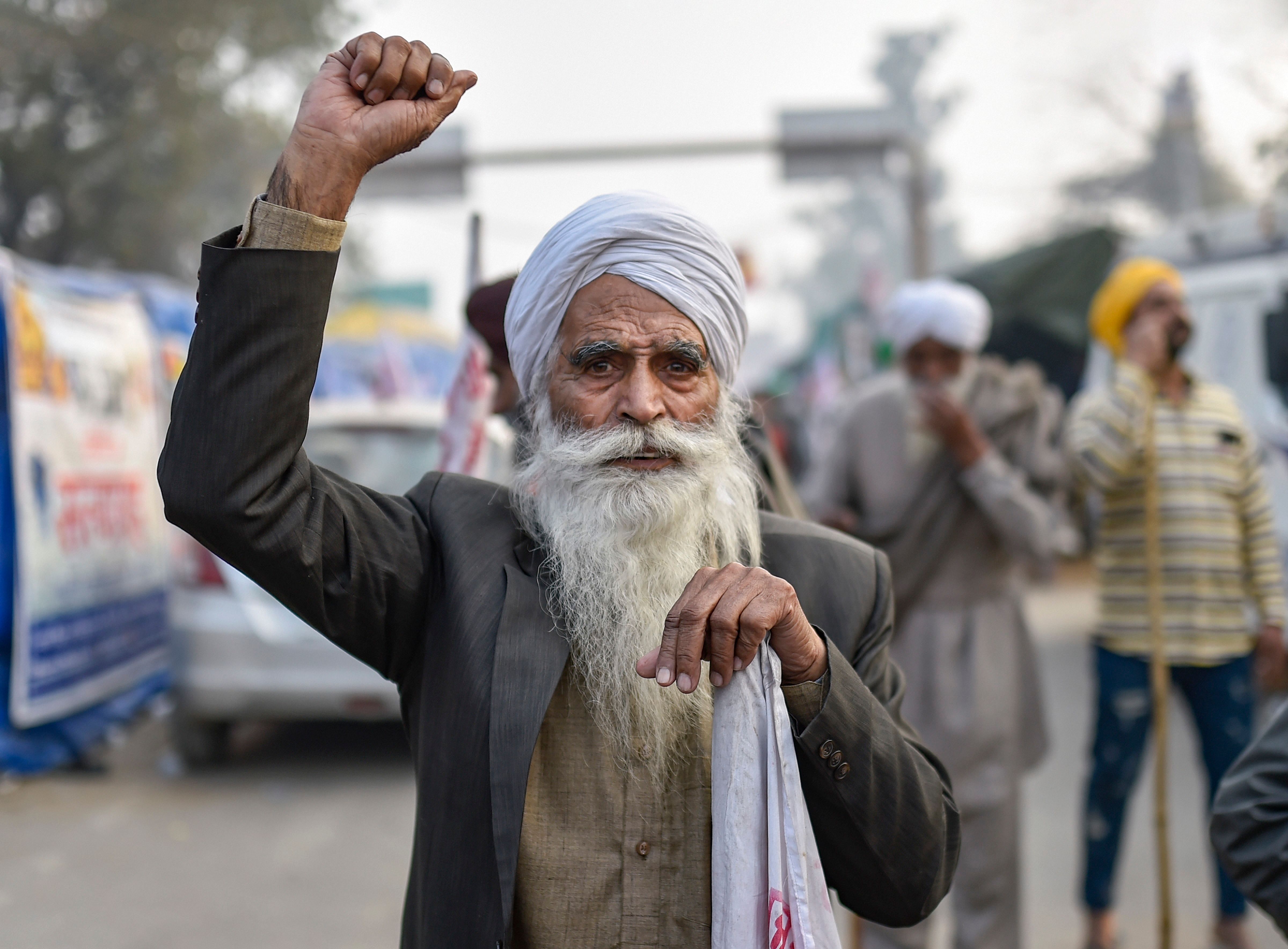  A Sikh farmers shouts slogans during the ongoing agitation against the new farm laws, at Singhu border. Credit: PTI Photo