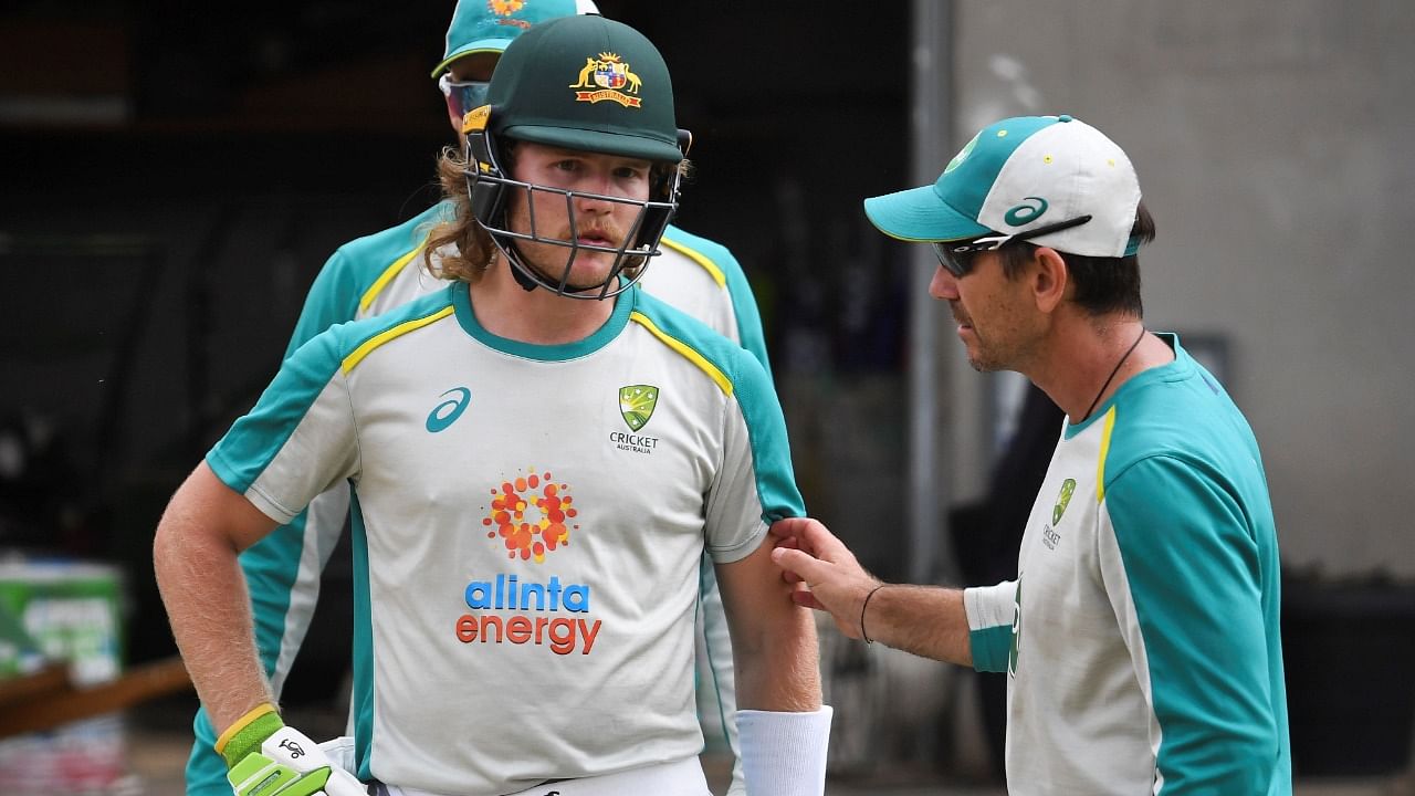 Australia's Will Pucovski (L) chats with coach Justin Langer (R) in the nets during a training session at the MCG in Melbourne. Credit: AFP File Photo