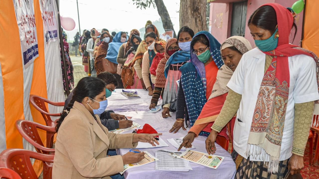 Anganwadi workers stand in a queue as they wait for their turn to get vaccinated during the COVID-19 vaccination drive, at a government hospital in Mirzapur. Credit: PTI.