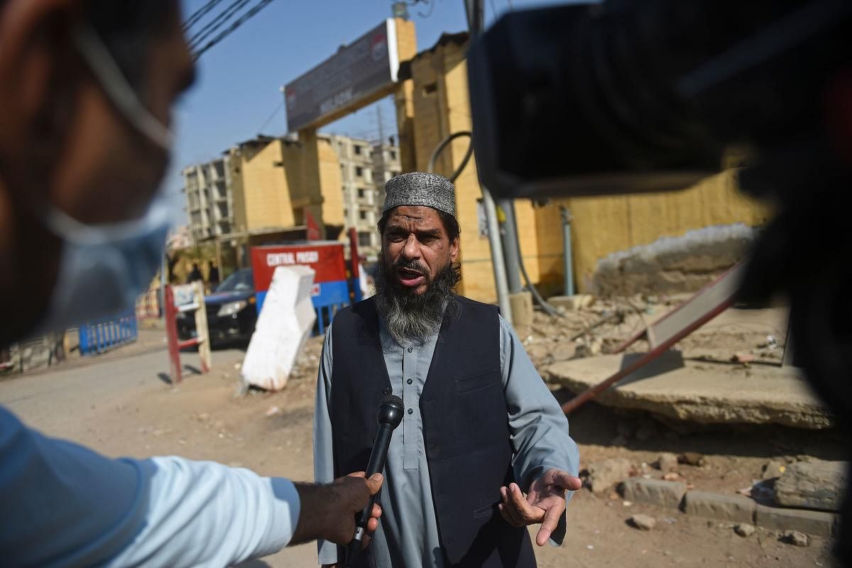 Sheikh Aslam, brother of Sheikh Adil, one of the accused of murdering US journalist Daniel Pearl, speaks with media representatives outside the central prison where British-born militant Ahmed Omar Saeed Sheikh, convicted of masterminding the kidnap and murder of Pearl, is serving his prison sentence in Karachi. Credit: AFP. 