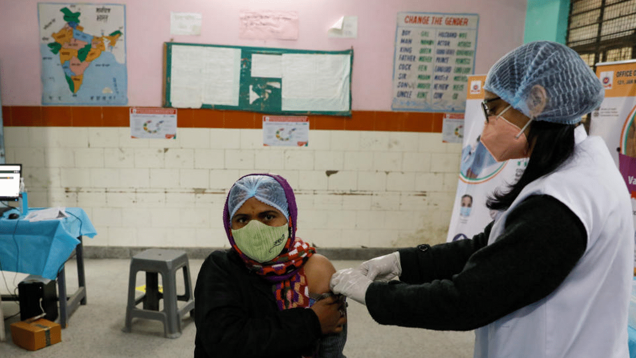  A health worker and a volunteer take part in a nationwide trial run of coronavirus disease (COVID-19) vaccine delivery systems, inside a school, which has been converted into a temporary vaccination centre, in New Delhi, India, January 8, 2021. Credit: Reuters File Photo