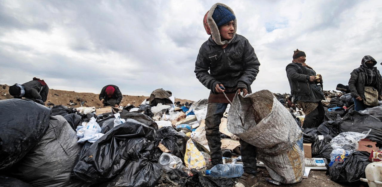 Syrians sift through a garbage dump in the countryside of Malikiya in northeast Syria. Credit: AFP. 