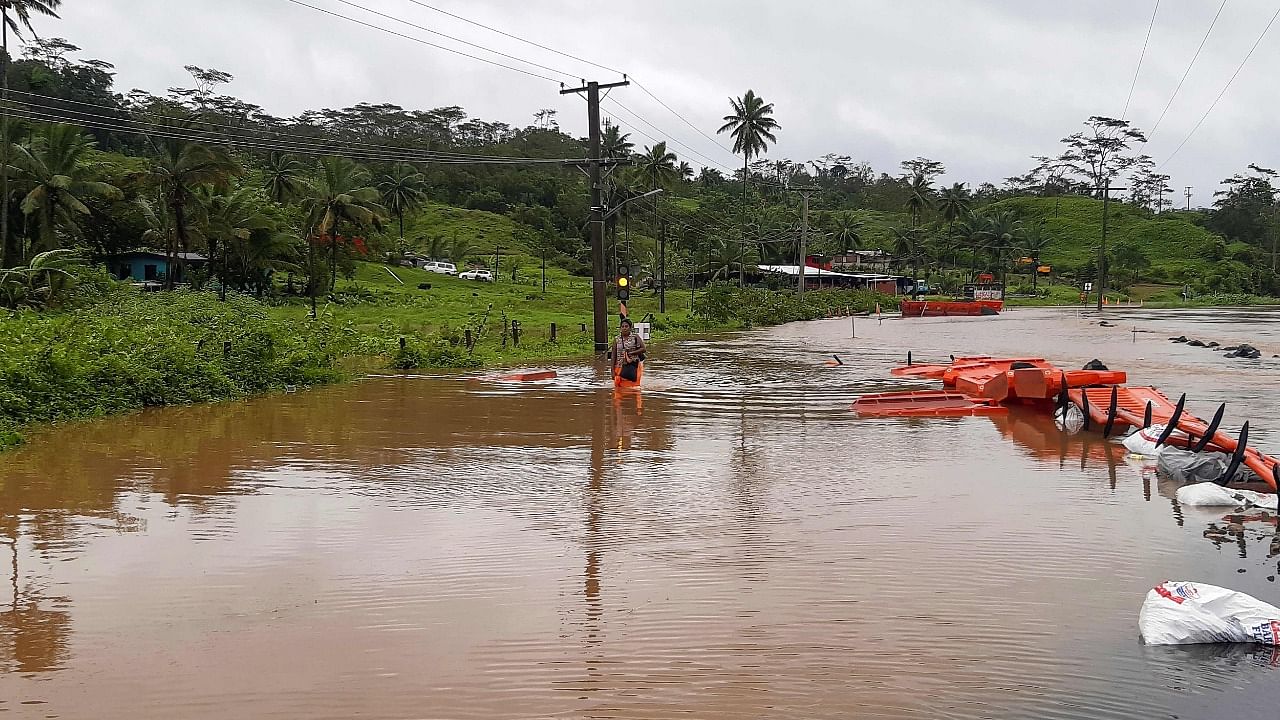 A resident wades through a street flooded by rain brought by Cyclone Ana, a category two storm, in the village of Sawani, north of Fiji's capital city of Suva. Credit: AFP Photo.