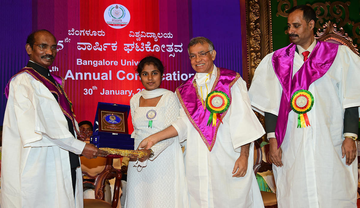 ISRO Chairman K Sivan presents gold medals to M Kavya (MA Kannada) at the BU convocation on Saturday. Vice-Chancellor K R Venugopal and Registrar (Evaluation) K R Venugopal are also seen. Credit: DH. 