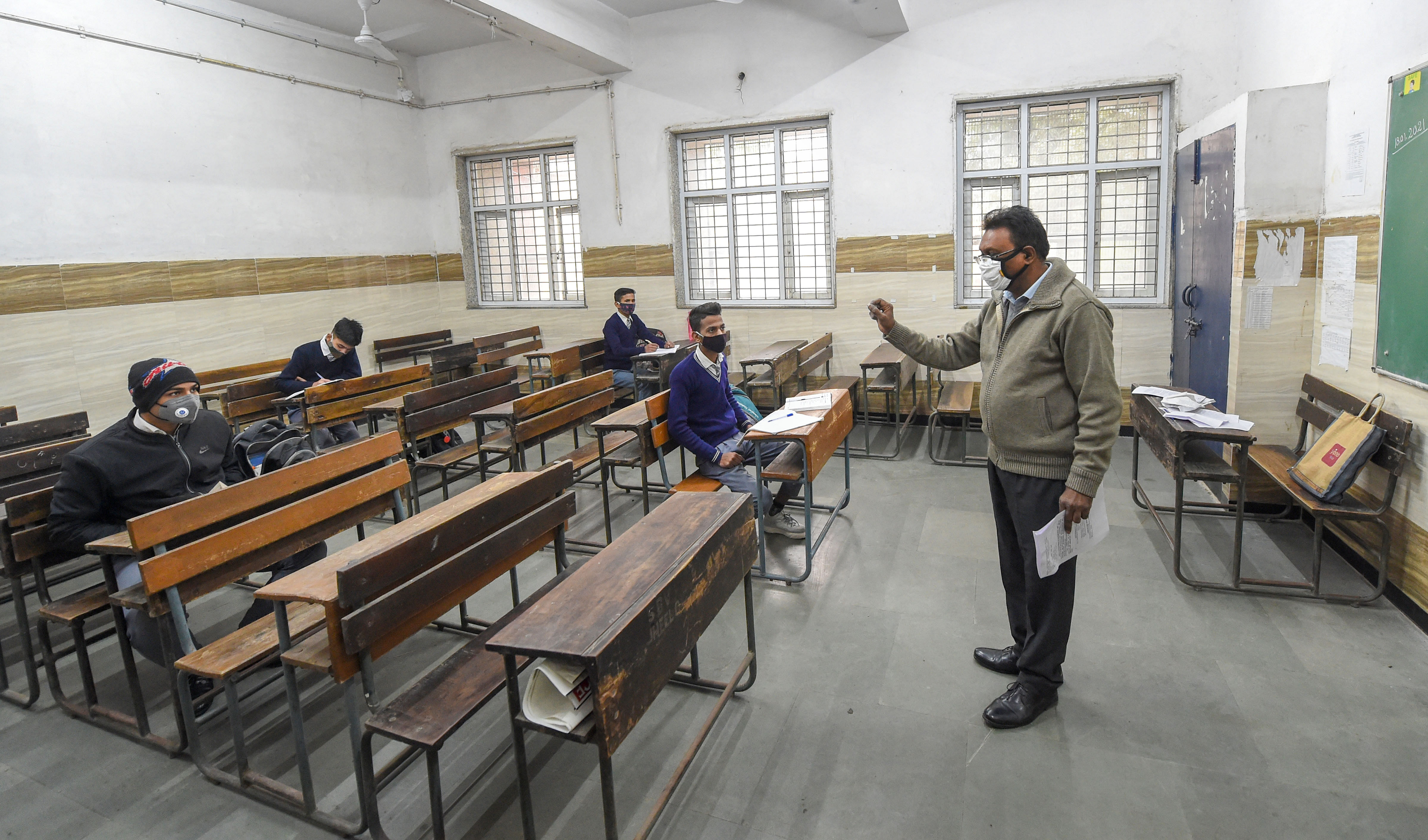 A teacher takes a class at a Rajkiya Sarvodaya Bal Vidyalaya, as schools in the national capital reopened for students of class 10 and 12, after remaining shut since March 19, 2020 due to coronavirus pandemic, in east Delhi, Monday, Jan. 18, 2021. Credit: PTI Photo