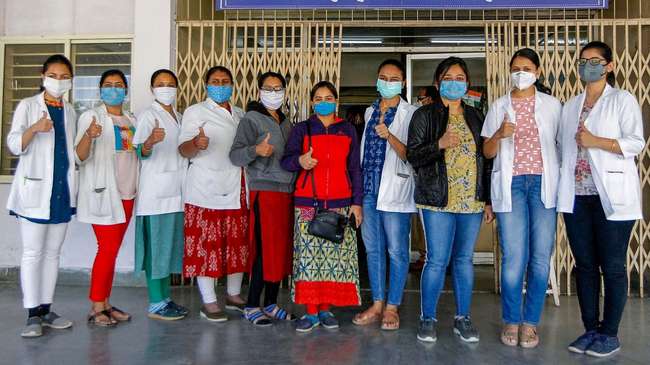 Health workers display thumbs-up signs after taking Covid-19 vaccine shots at the Civil hospital in Ahmedabad. Credit: PTI File Photo.