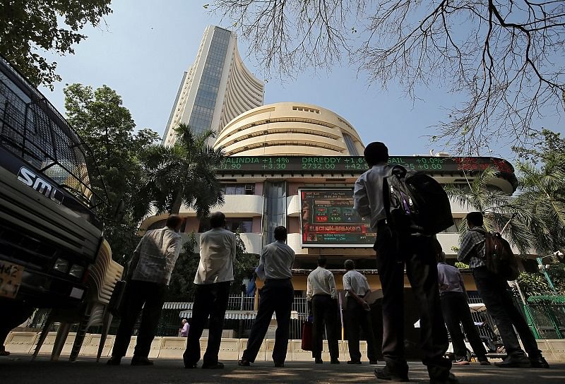 People look at a screen displaying the Sensex results on the facade of the Bombay Stock Exchange (BSE) building in Mumbai. (Reuters Photo)