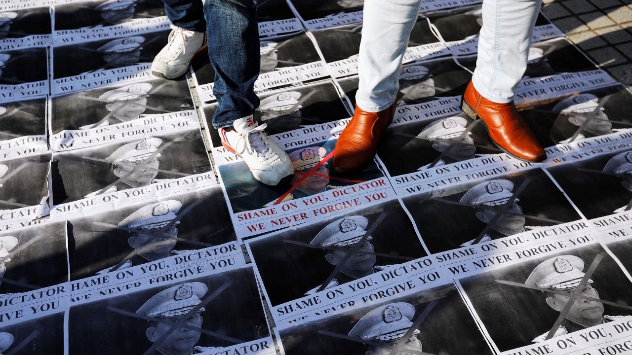 Protesters stand on pictures of Myanmar's army chief Min Aung Hlaing as they rally against Myanmar's military after it seized power from a democratically elected civilian government and arrested its leader Aung San Suu Kyi, in Tokyo. Credit: Reuters Photo