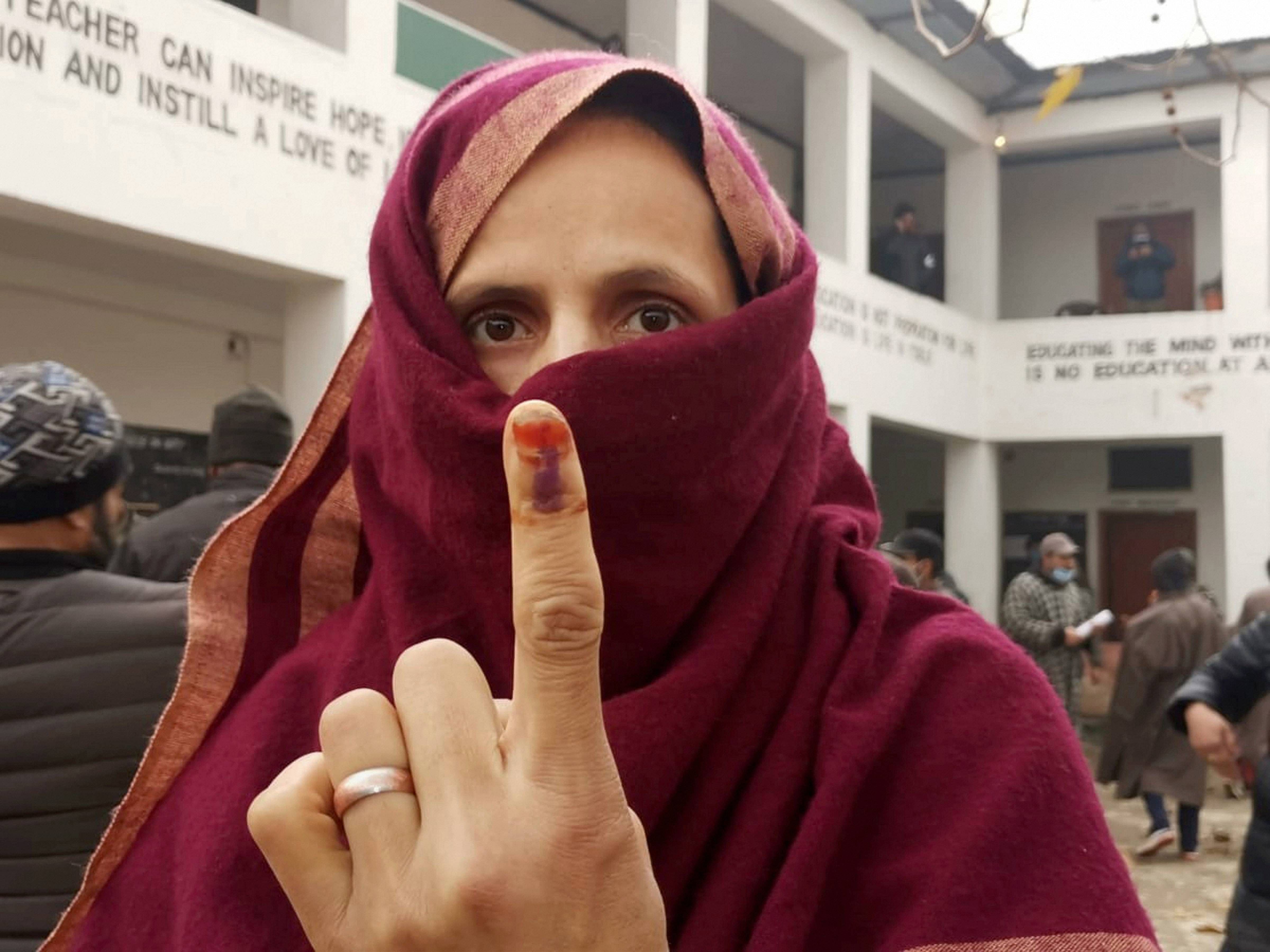 A woman shows her ink-marked finger after casting her vote during the third phase of DDC elections, at a polling station in Ganderbal area of Central Kashmir, Friday, Dec. 4, 2020. Credit: PTI Photo