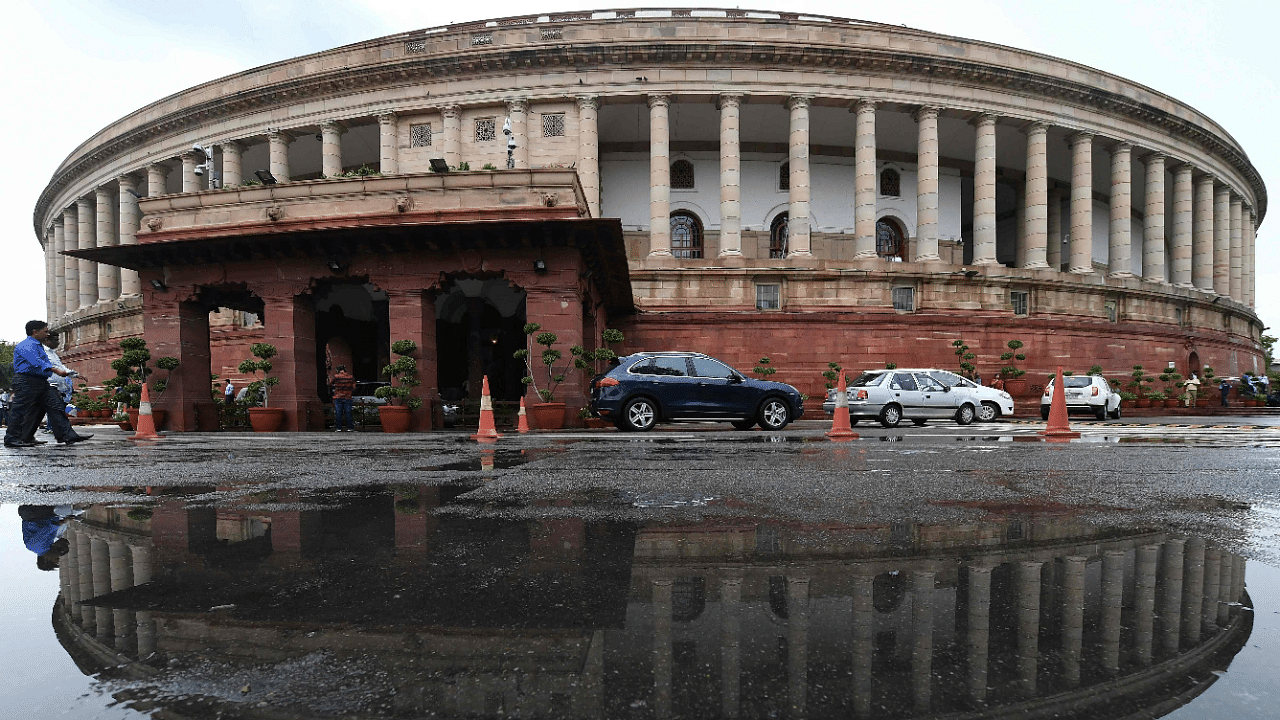 Parliament building is reflected in a puddle after heavy rain during the monsoon session of the Indian Parliament. Credit: AFP Photo