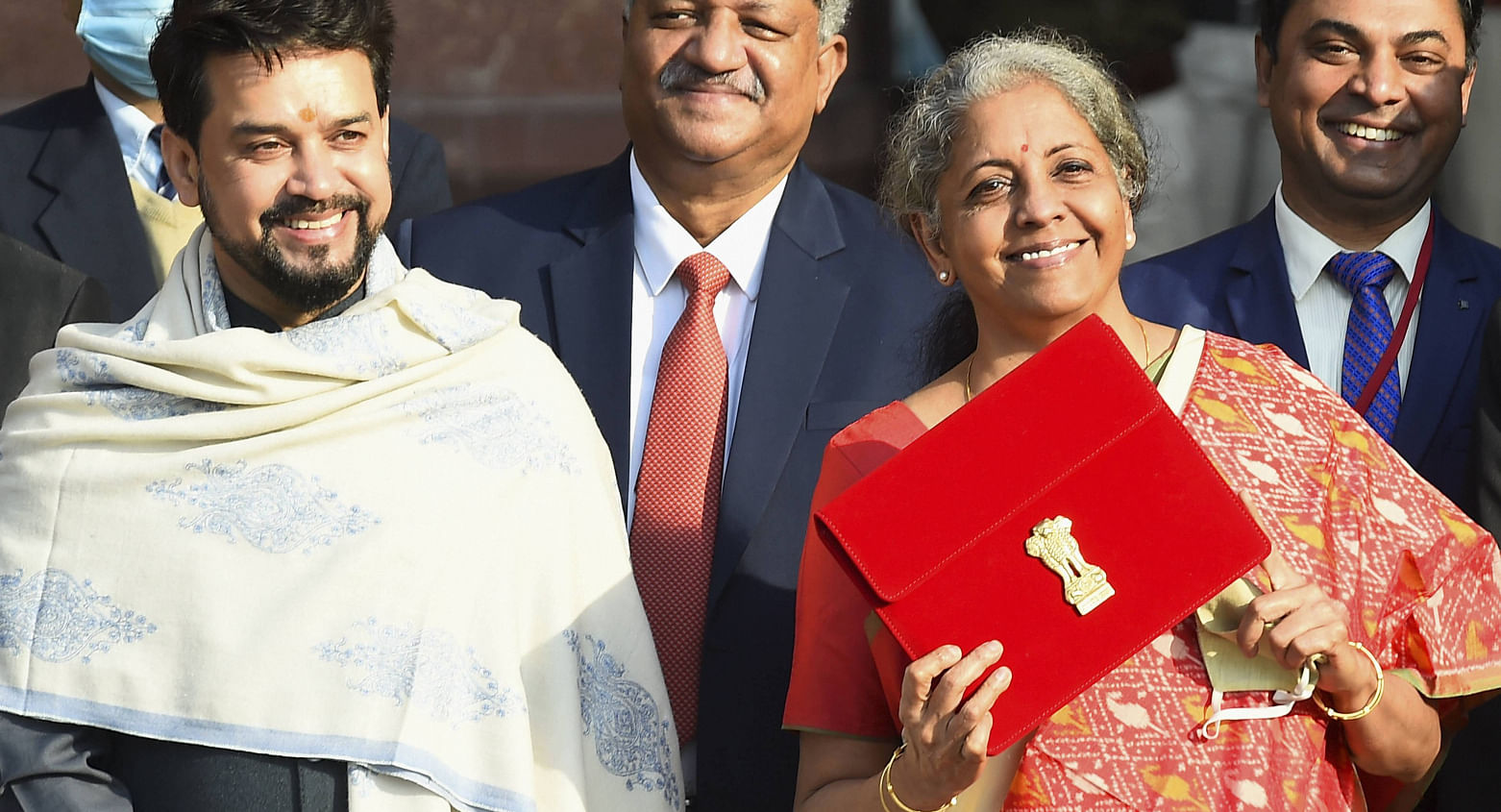 Union Finance Minister Nirmala Sitharaman holds up a folder with the Government of India logo, as India's Chief Economic Advisor Krishnamurthy Subramanian and Minister of State for Finance and Corporate Affairs Anurag Thakur look on as she leaves her office to present the Union Budget in the parliament in New Delhi, India, February 1, 2021. Credit: PTI Photo