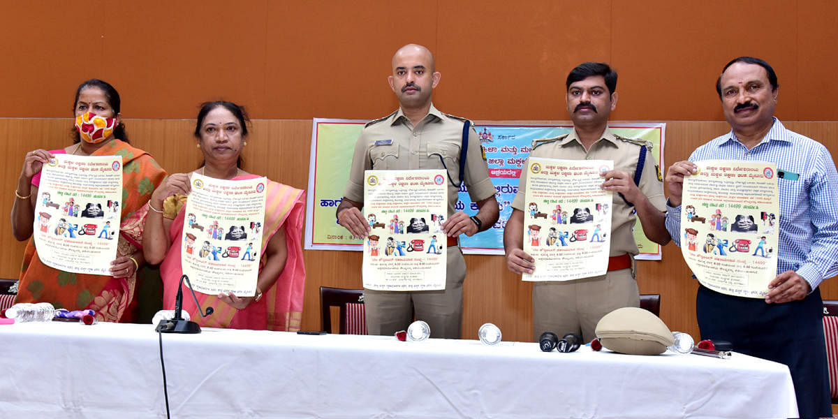 Superintendent of Police C B Ryshyanth releases posters of 14499 helpline, during a training programme on child adoption, at SP’s office in Mysuru on Wednesday. Women and Child Development Deputy Director K Padma, ASP Shivakumar are seen. DH PHOTO