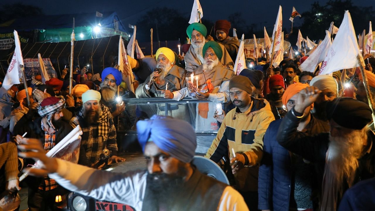 Farmers take part in a candlelit vigil, in memory of a person who died during a tractor rally on India’s Republic Day, as protests against farm laws continue, at Singhu Border near New Delhi. Credit: Reuters Photo.