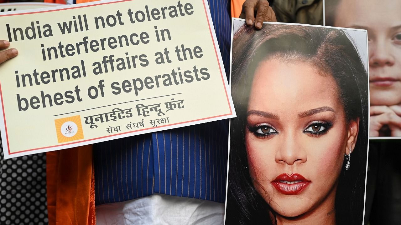 Activists of United Hindu Front (UHF) hold a placard and pictures of Swedish climate activist Greta Thunberg and Barbadian singer Rihanna during a demonstration in New Delhi. Credit: AFP Photo