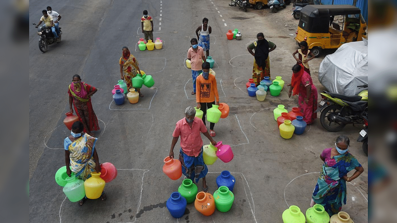 People maintain social distance as they stand in queues to collect drinking water in Chennai. Credit: PTI Photo