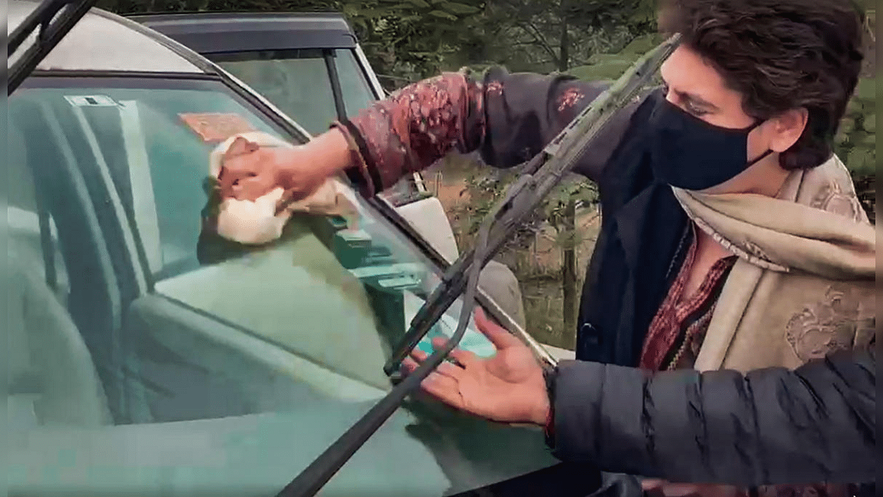 Congress General Secretary Priyanka Gandhi Vadra cleans the windshield of her vehicle while enroute to UP's Rampur district to visit family members of Navreet Singh, who died after his tractor overturned during the farmers rally on Republic Day, Thursday, Feb. 4, 2021. Credit: PTI Photo