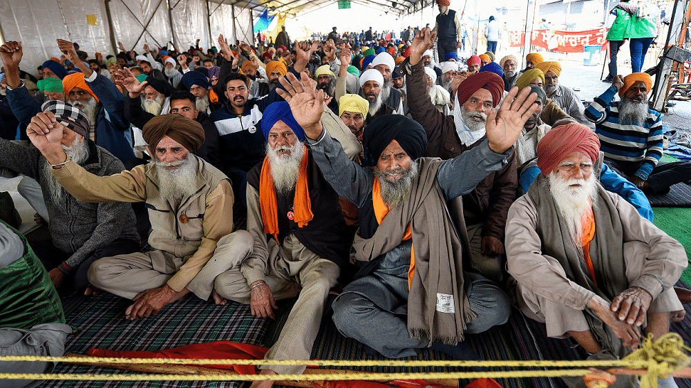 Farmers raise slogans during their ongoing agitation against Centre's farm reform laws, at Singhu border. Credit: PTI Photo