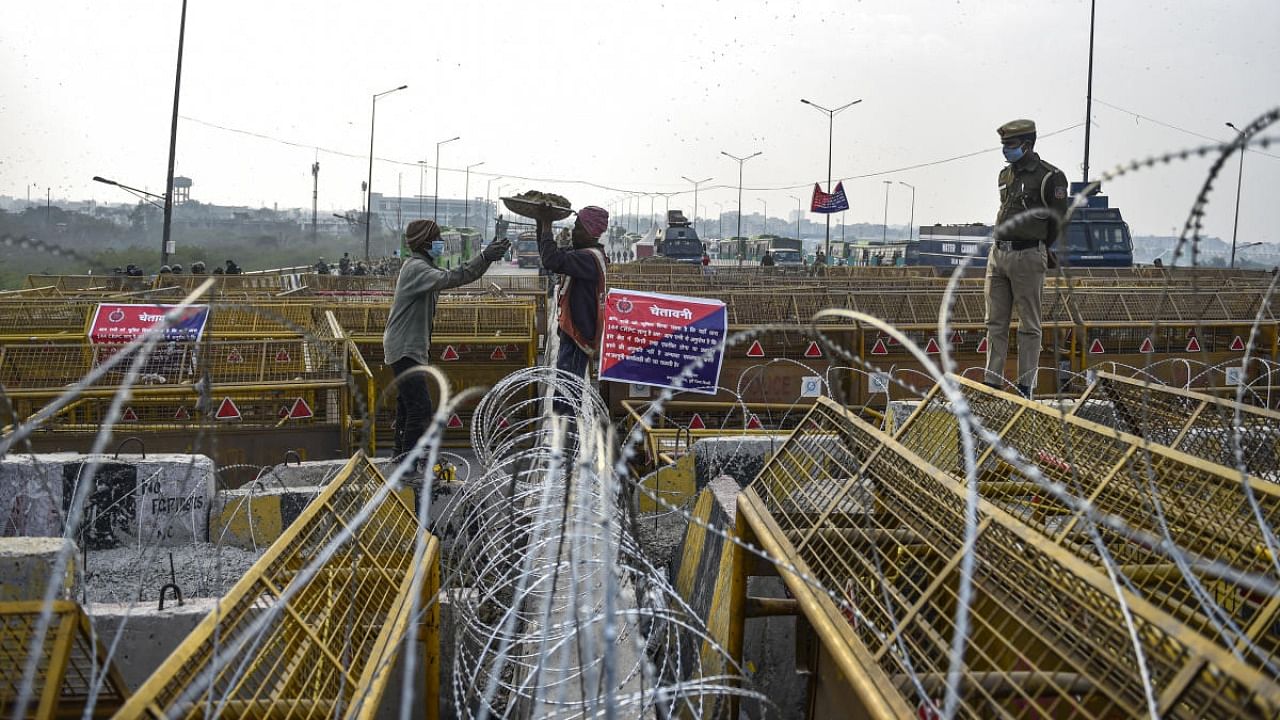 Barbed wires put across a road by Delhi Police to stop farmers from entering the national capital during their protest against the new farm laws, at Ghazipur border in New Delhi. Credit: PTI.
