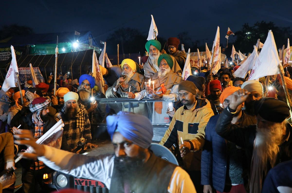 Farmers take part in a candlelit vigil, in memory of a person who died during a tractor rally on India’s Republic Day, as protests against farm laws continue, at Singhu Border near New Delhi, India, February 4, 2021. Credit: REUTERS