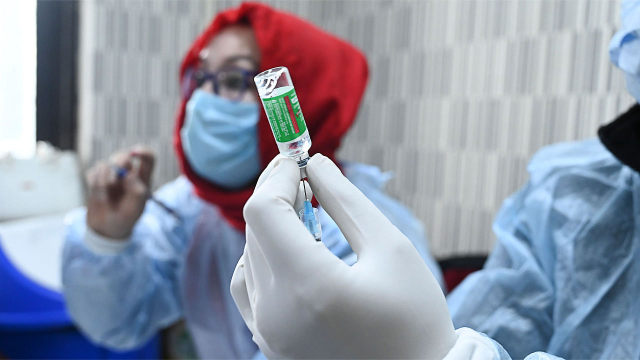A medical worker prepares to inoculate a police personnel with a Covid-19 coronavirus vaccine at the Police headquarters in Srinagar. Credit: AFP Photo