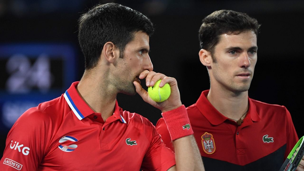 Serbia's Novak Djokovic (L) talks to partner Nikola Cacic during their ATP Cup group A men's doubles tennis match against Germany's Jan-Lennard Struff and Alexander Zverev in Melbourne on February 5, 2021. Credit: AFP Photo