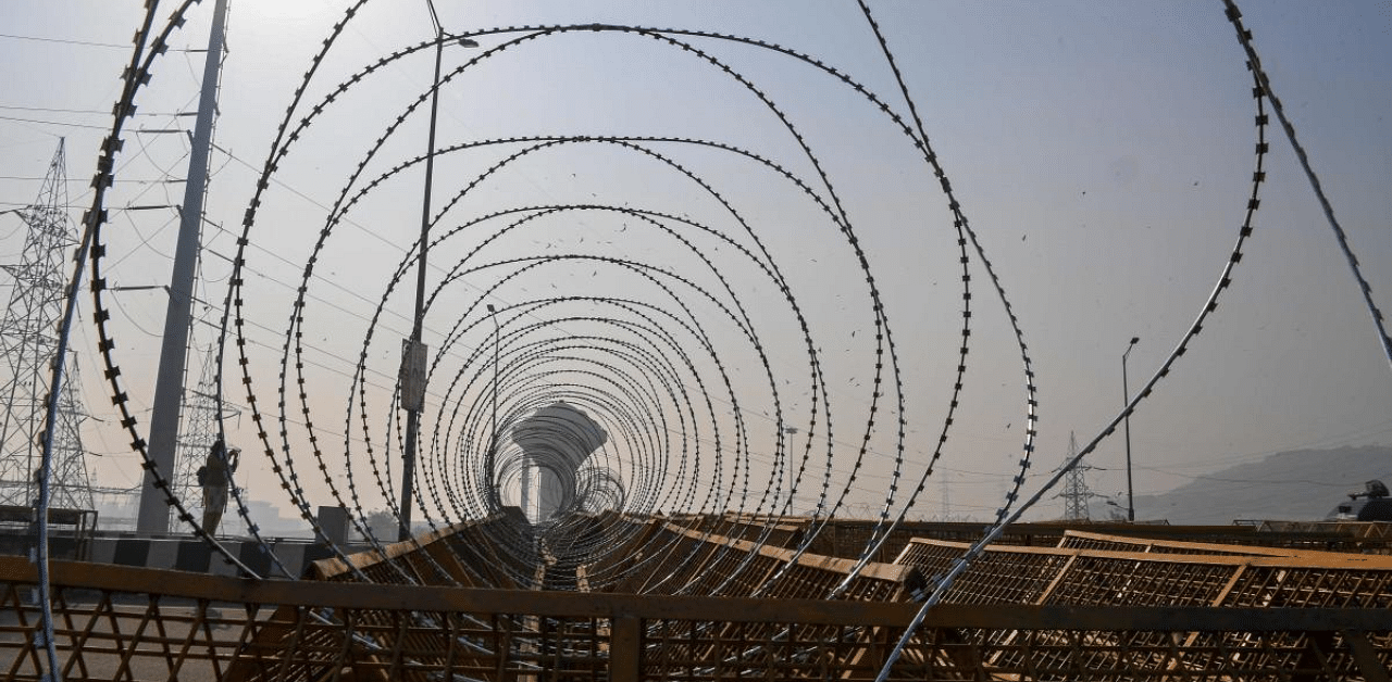 Barbed wires are seen on police barricades along a blocked highway as farmers continue their protest against the Central Government's recent agricultural reforms at Delhi-Uttar Pradesh state border. Credit: AFP Photo