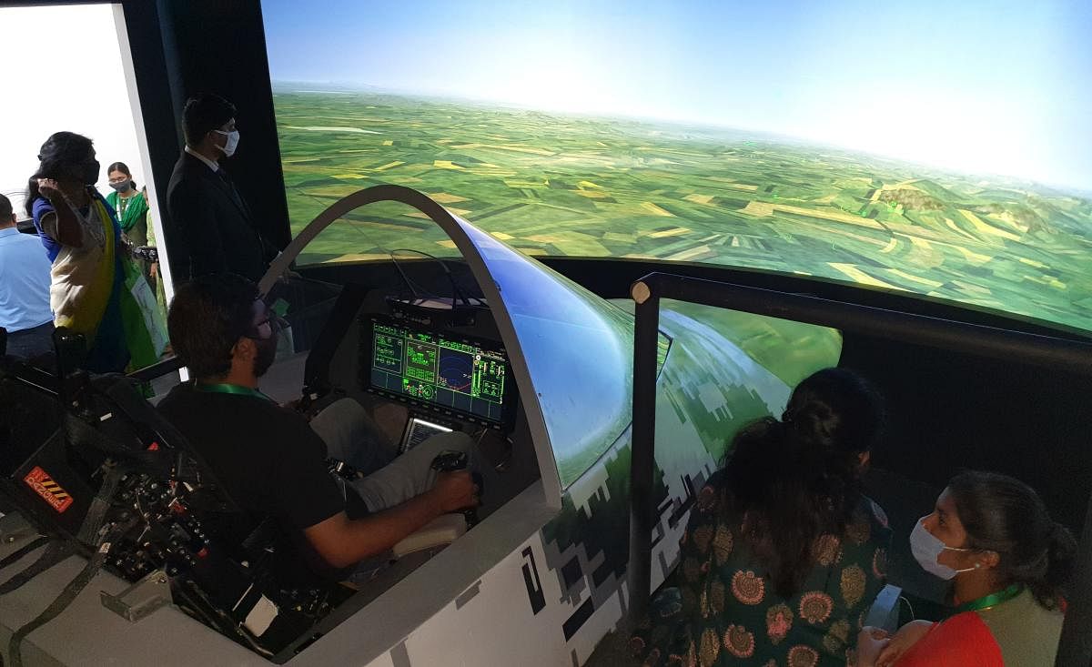 A visitor in the cockpit of AMCA jet trainer simulator, designed and developed by Aeronautical Development Agency (ADA) at the air show 2021 in Bengaluru on Thursday. DH PHOTO/RASHEED KAPPAN