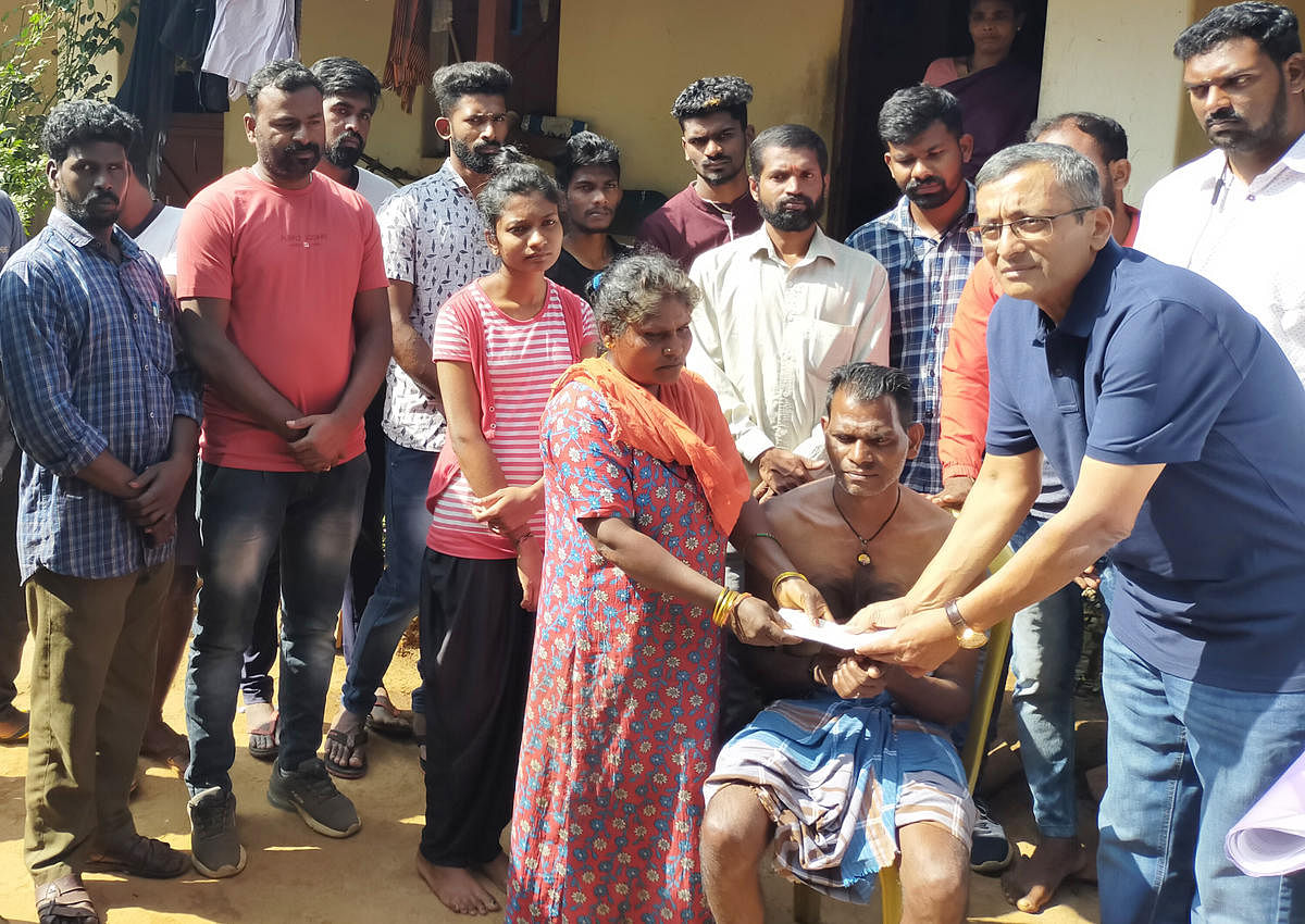 Social worker Sanketh Poovaiah hands over financial assistance to a labourer who has been permanently disabled due to an elephant attack.