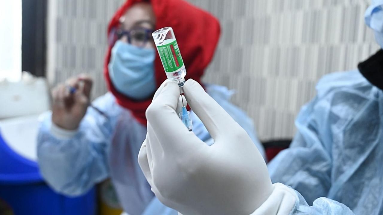 A medical worker prepares to inoculate a police personnel with a Covid-19 coronavirus vaccine at the Police headquarters in Srinagar. Credit: AFP.