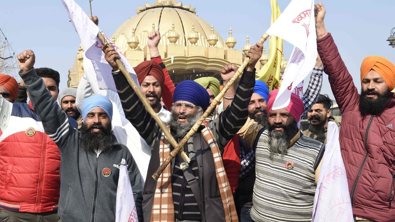 Farmers shout slogans blocking a highway during a roadblock-protest, part of their continuing demonstration against the central government's recent agricultural reforms, on the outskirts of Amritsar. Credit: AFP Photo.