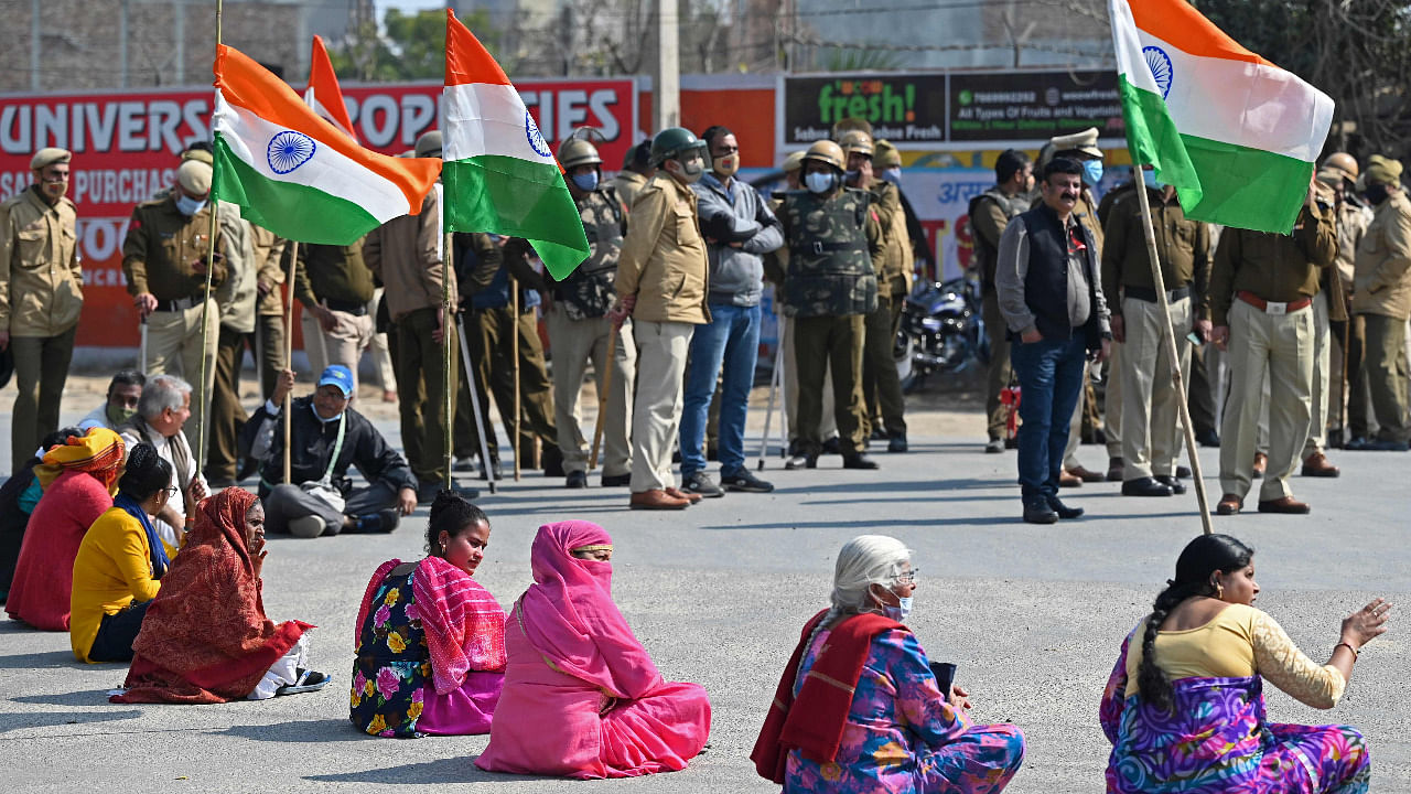 Protesters sit on a street during a roadblock-protest called by farmers, part of their continuing demonstration against the central government's recent agricultural reforms, in Gurugram. Credit: AFP Photo