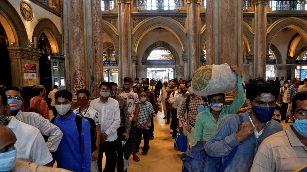People wearing protective face masks wait in queues to buy train tickets at the Chhatrapati Shivaji Maharaj Terminus (CSMT). Credit: Reuters Photo