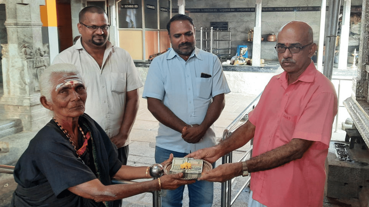 Ashwathamma hands over Rs 1 lakh donation to Gurunarasimha Temple in Saligrama. Credit: DH Photo