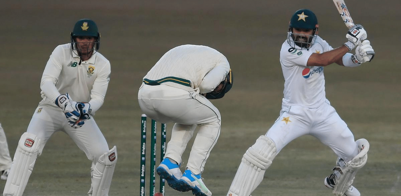 Pakistan's Mohammad Rizwan (R) plays a shot as South Africa's wicketkeeper captain Quinton de Kock (L) watches during the third day of the second Test cricket. Credit: AFP Photo