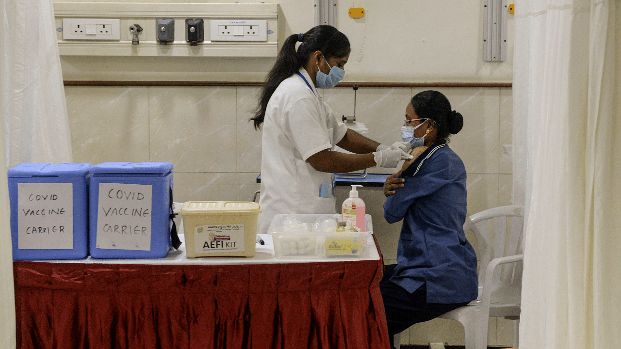 A medical worker (L) inoculates a frontline staff with a Covid-19 vaccine at KIMS hospital in Hyderabad. Credit: AFP Photo
