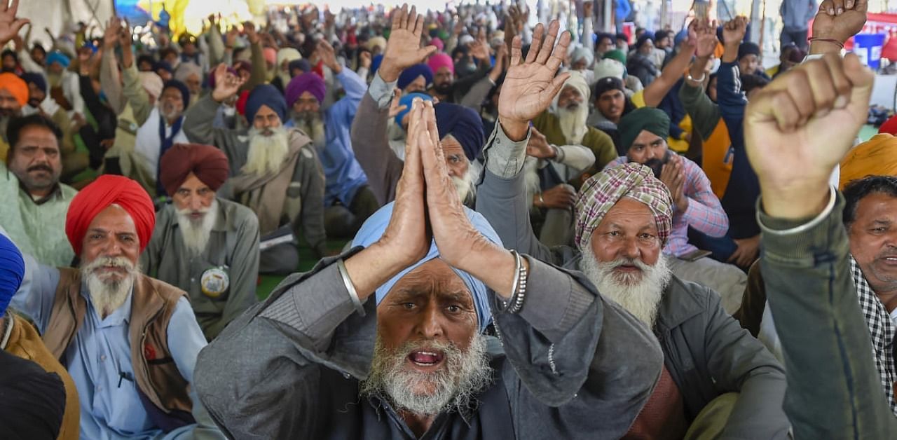 Farmers raise slogans during their ongoing agitation against Centre's farm reform laws, at Singhu border in New Delhi, Friday, Feb. 5, 2021. Credit: PTI Photo