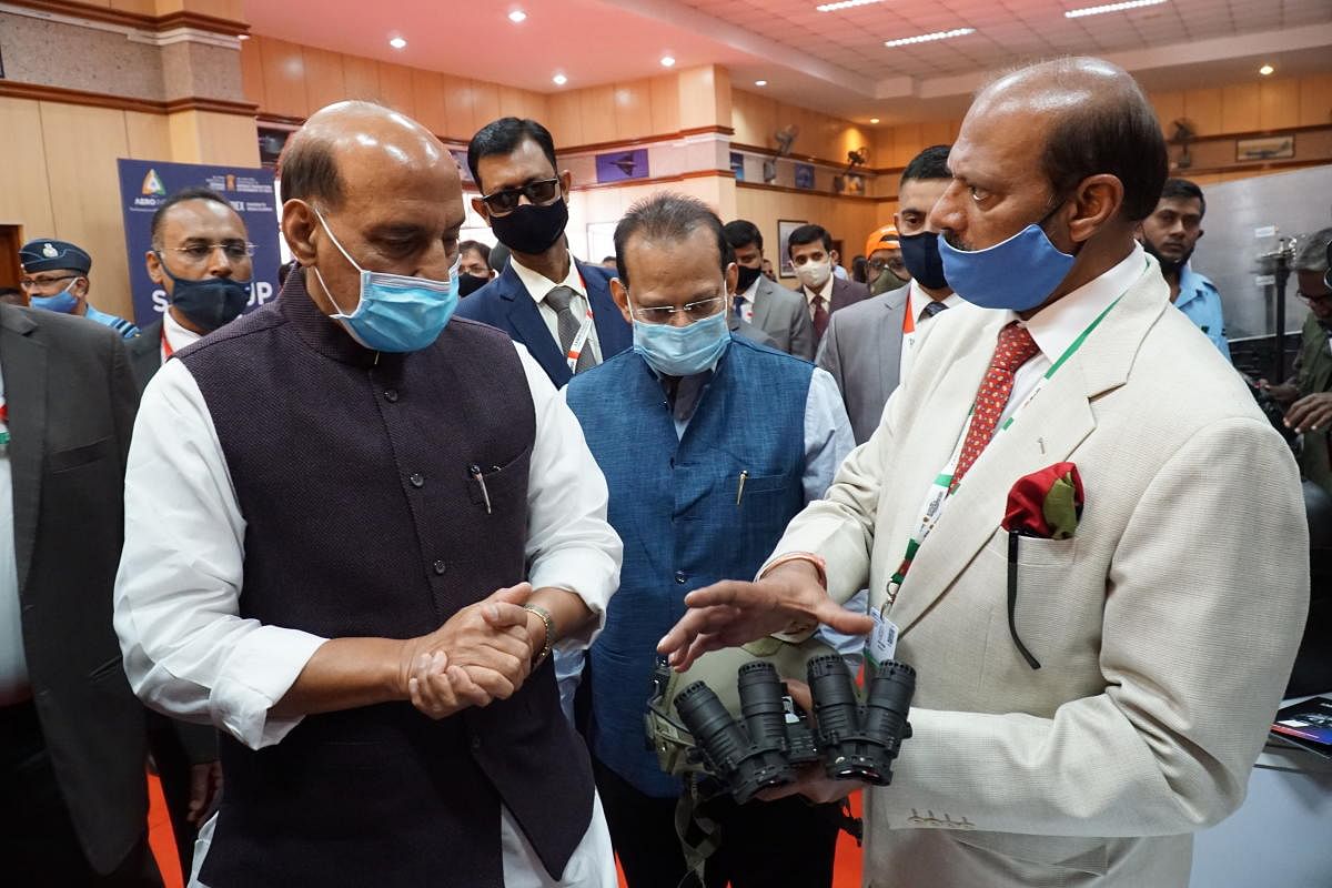Defence Minister Rajnath Singh looks at a night sight developed by an Indian startup firm at Aero India 2021.